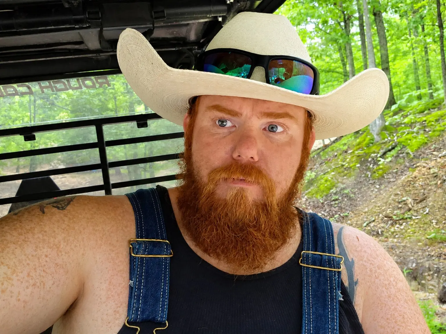 Justin Lafollette seated in a side-by-side on a wooded trail